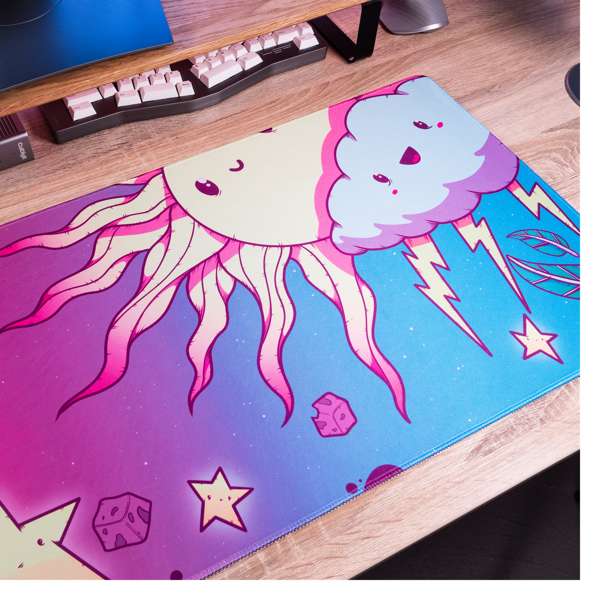 Wide view of cartoon desk mat showing blue cloud face, stars, and tentacle flames