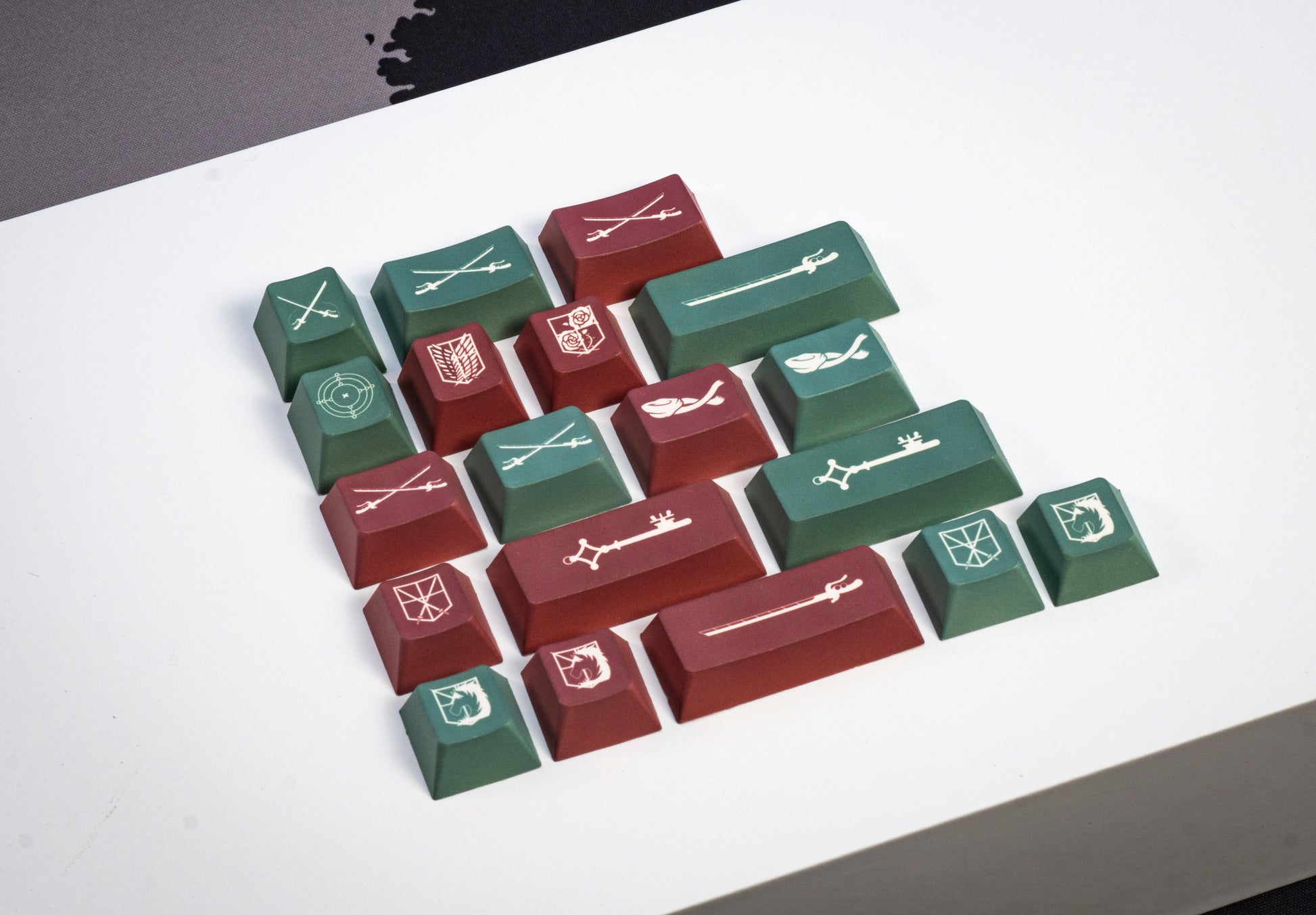Assorted PBT keycaps scattered: white, dark green, and red keys with white legends