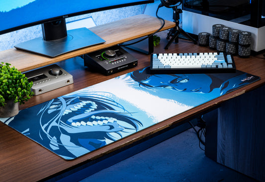 Rectangular desk mat with blue-and-white character graphic on tabletop
