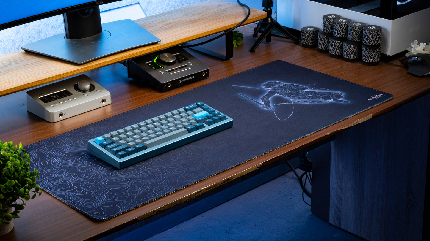 Dark blue anime desk mat with character silhouette line art and dark contour swirl design