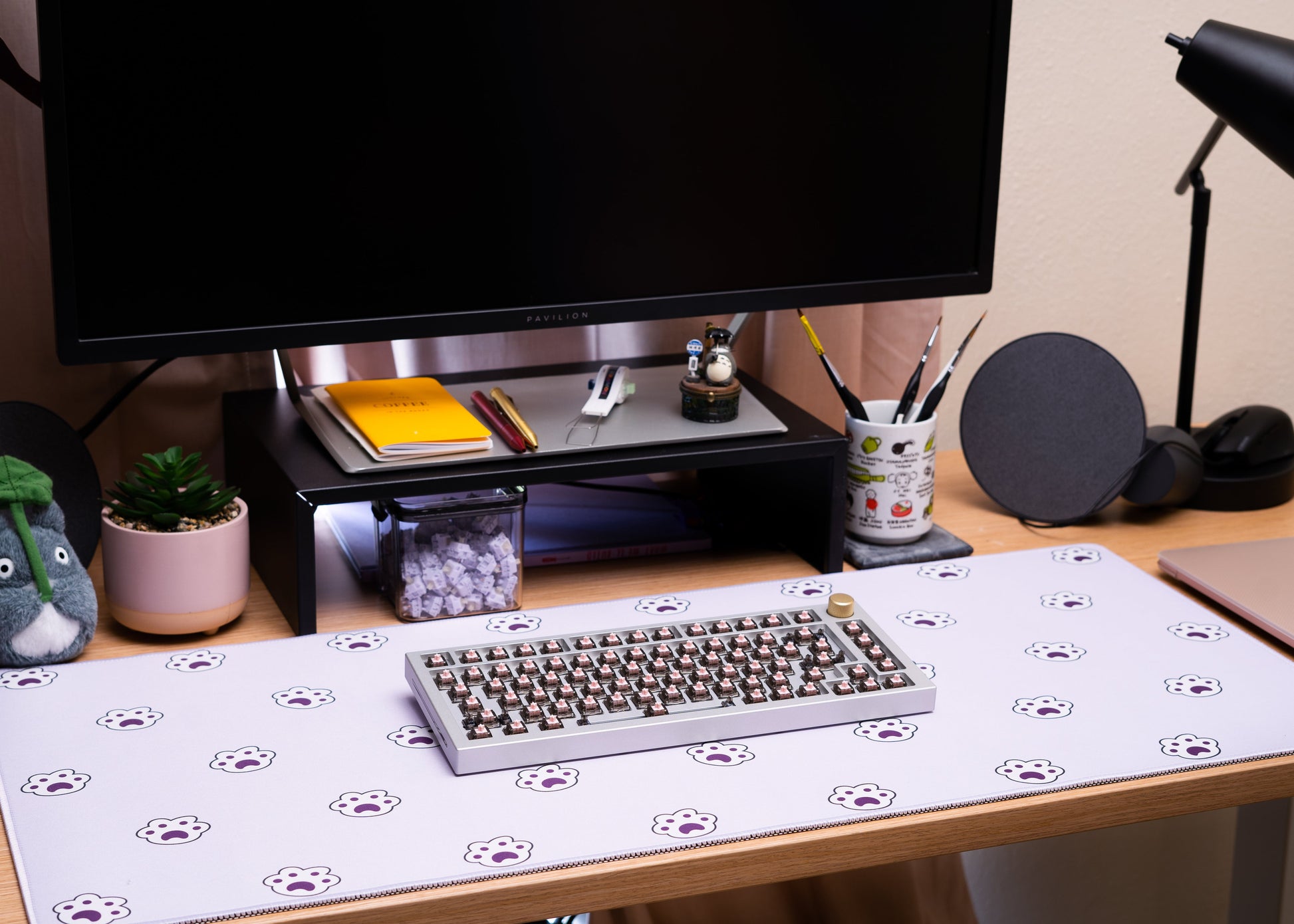 Lavender desk mat with paw-print icons, keyboard centered on a desk