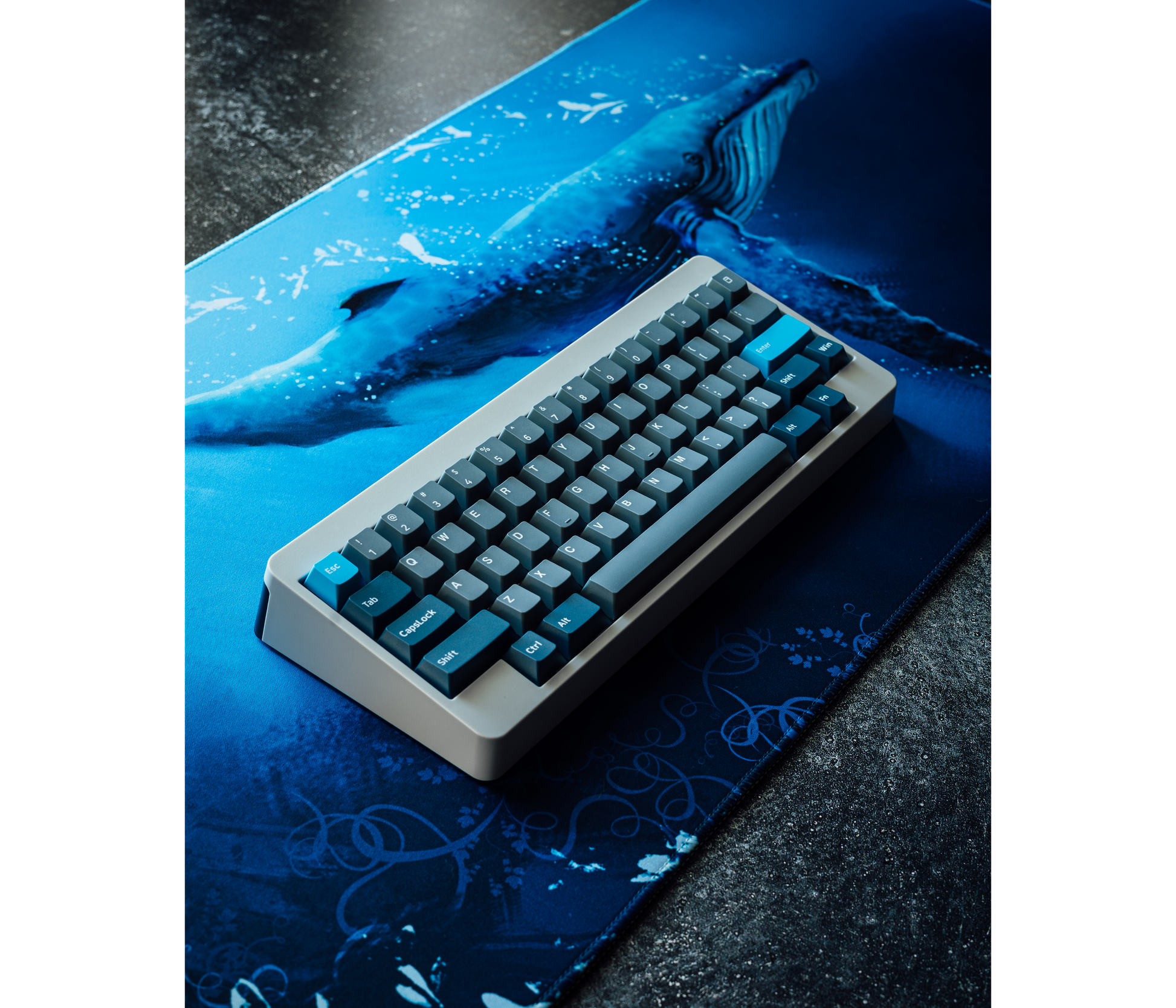 Desk mat with blue whale illustration beneath a keyboard