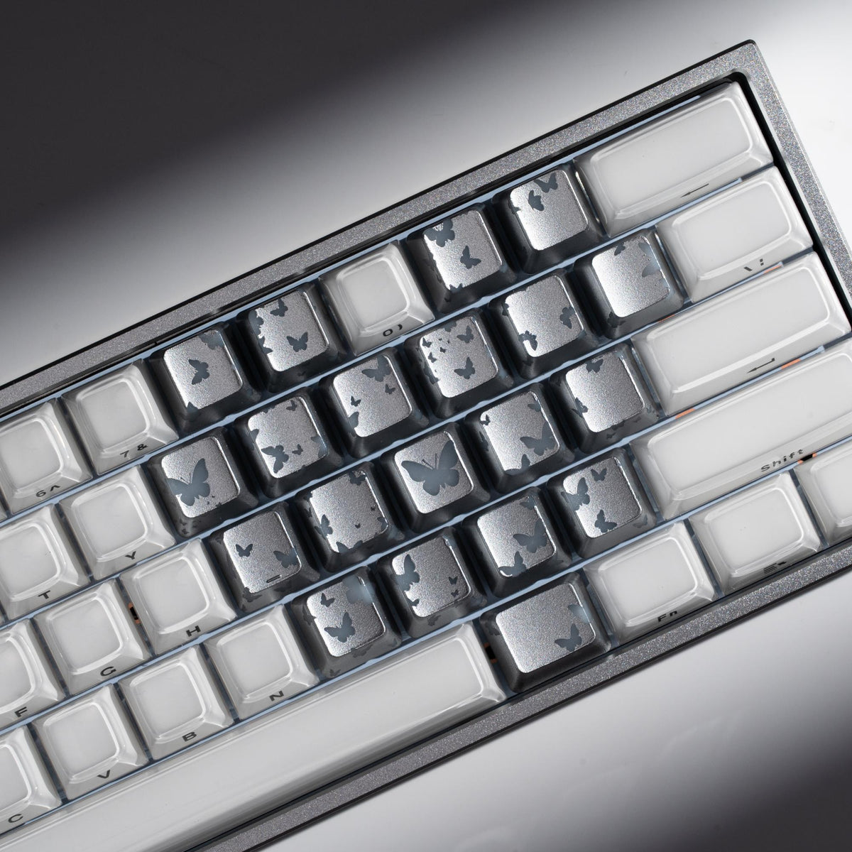Backlit keycap grid with dark butterfly cutout motifs across white keys