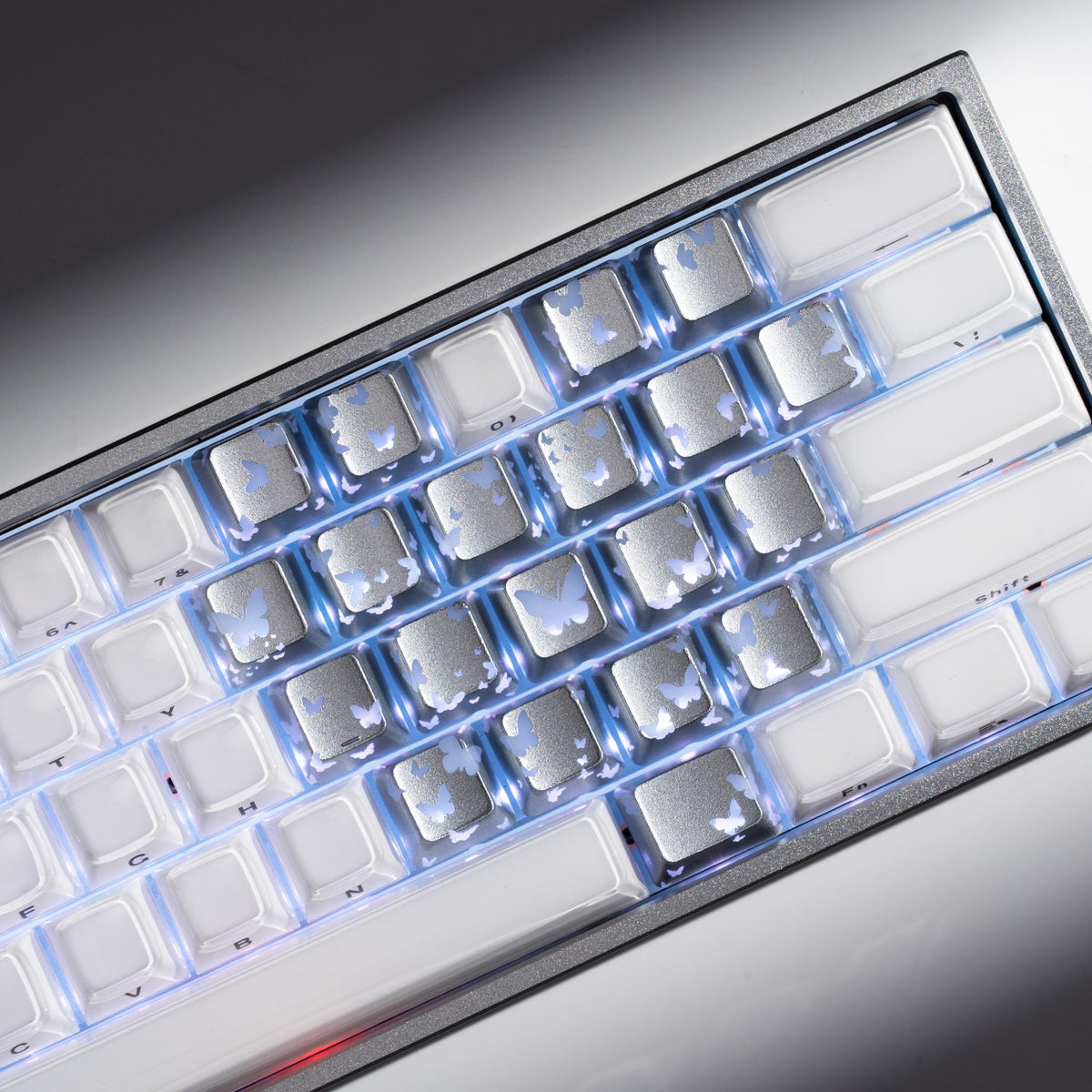 Silver-tone keyboard keycaps with backlit butterfly cutouts and square legends