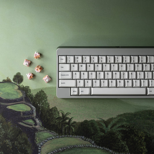Green landscape desk mat with distant-hills print; keyboard edge visible