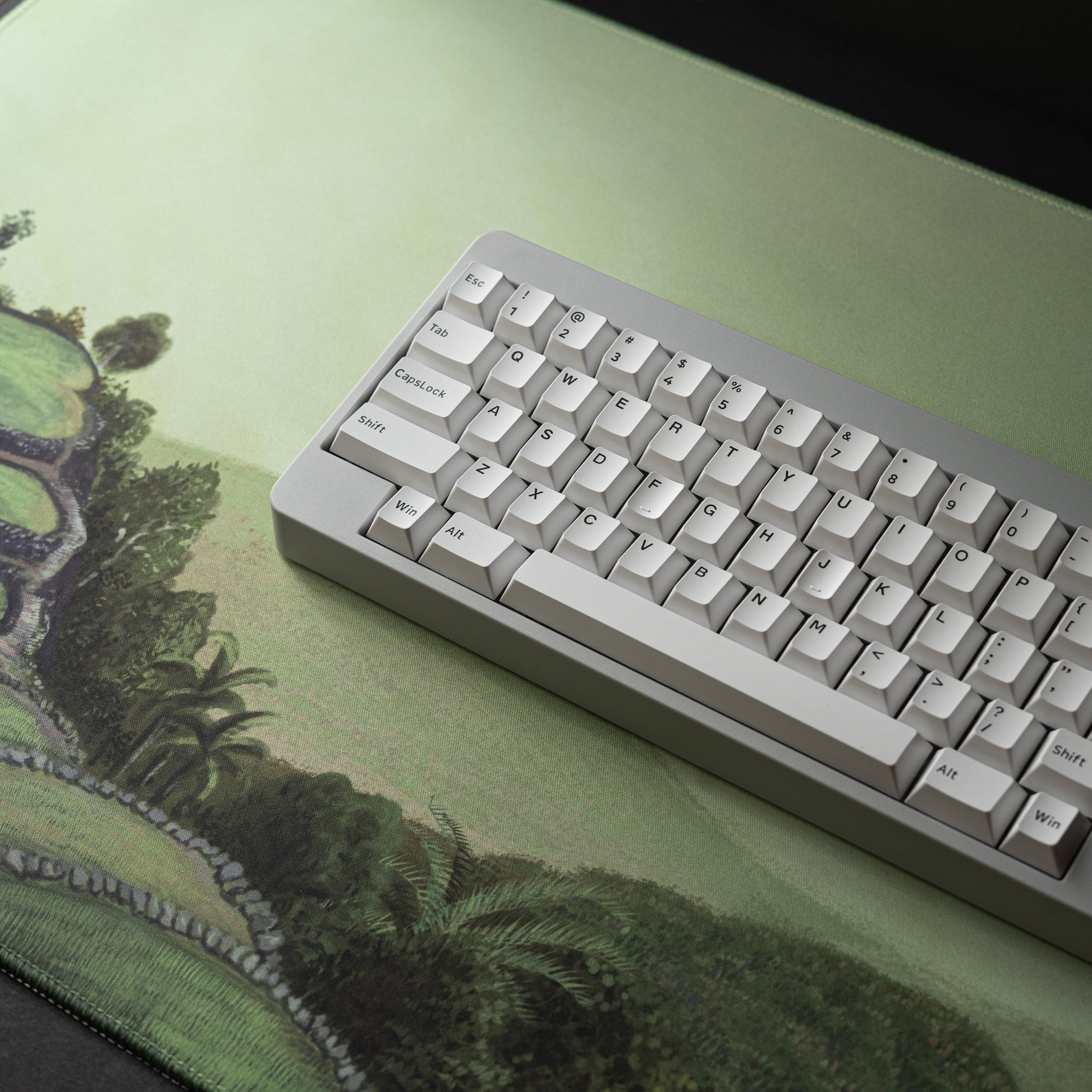 Green landscape desk mat with stitched edge border and keyboard on top