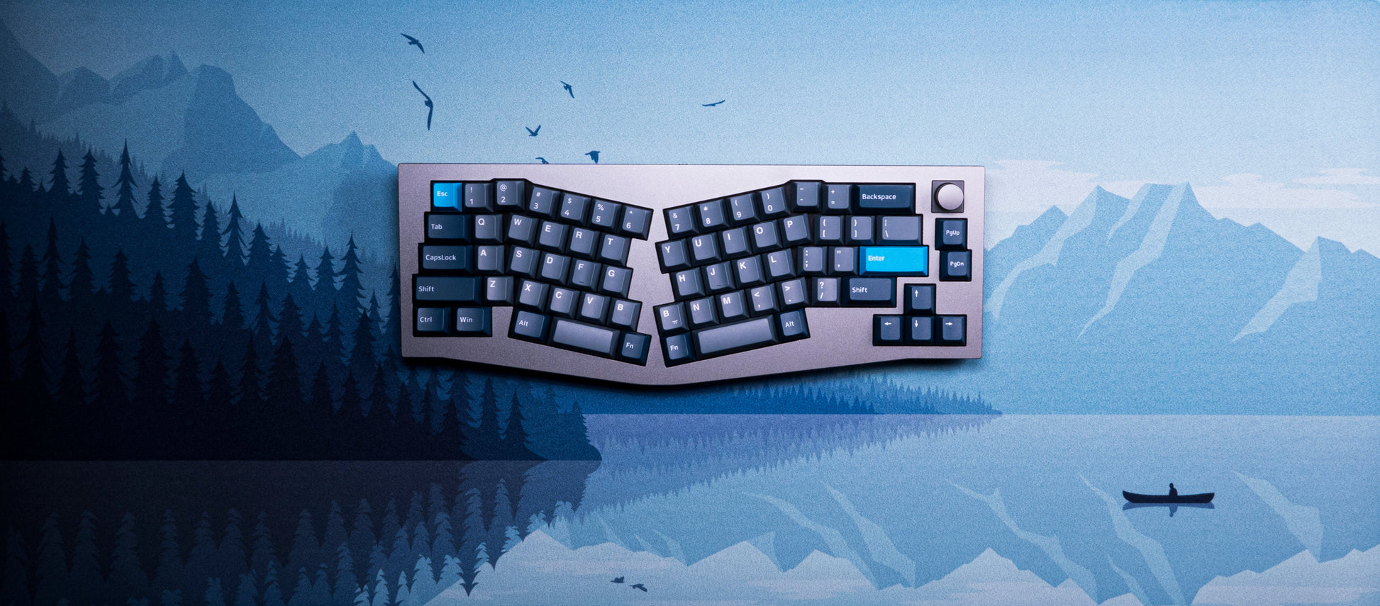 Alberta V2 desk mat with light blue landscape and keyboard keycaps on top