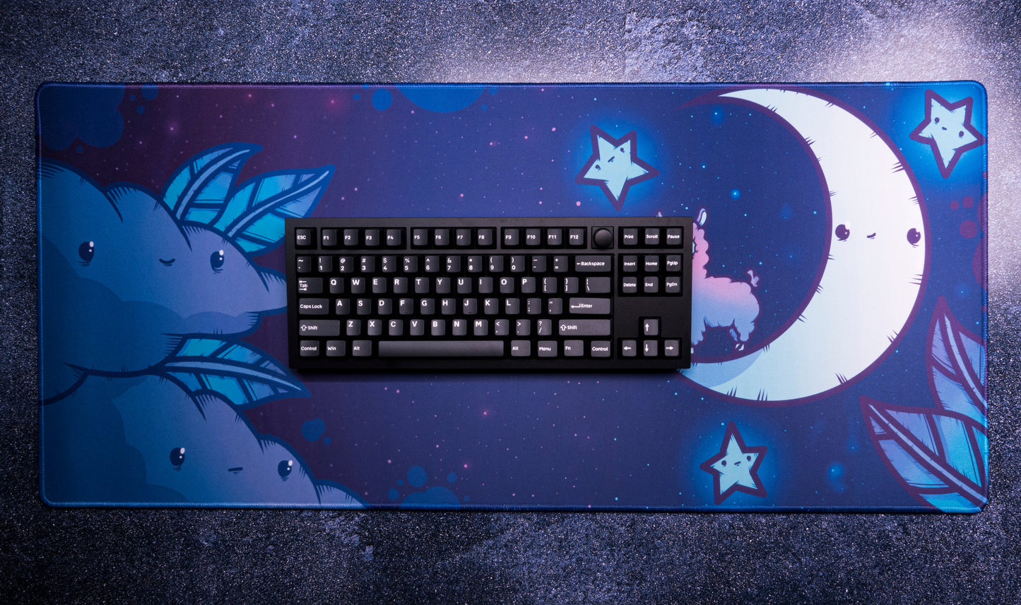 Desk mat with alpaca, crescent moon, and stars; keyboard shown on top
