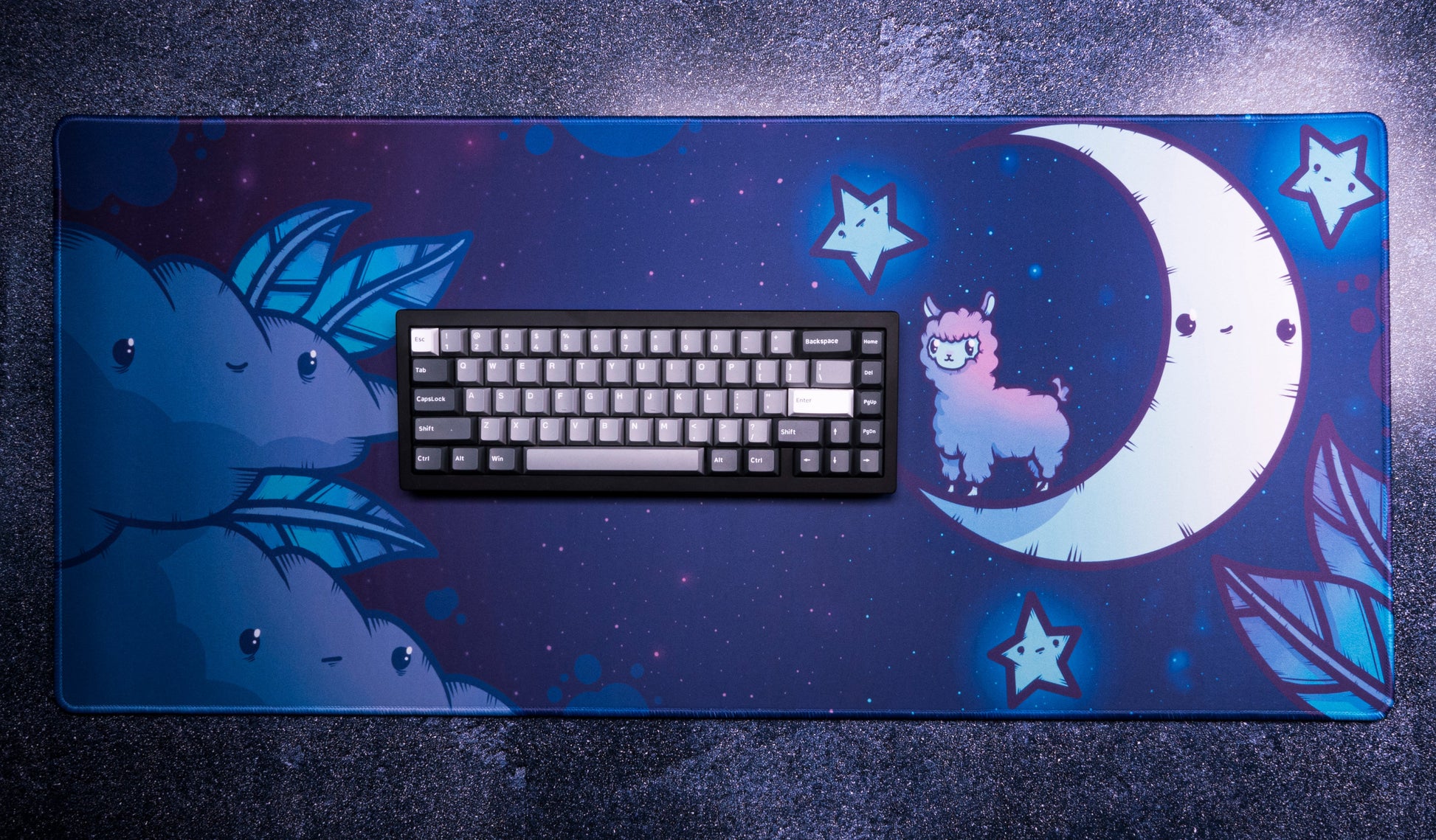 Rectangular desk mat with alpaca, crescent moon, and star icons; keyboard centered