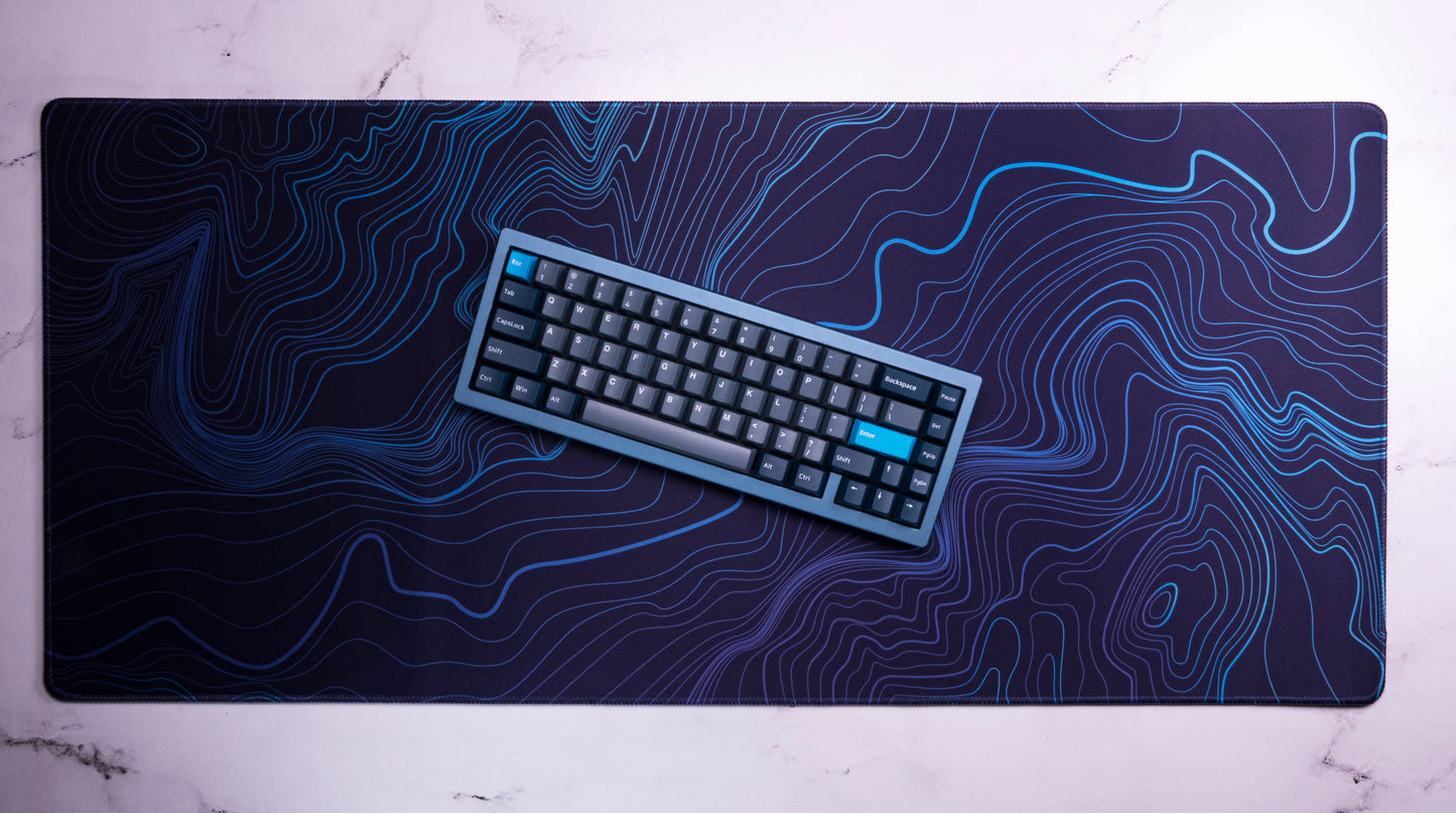 Purple-blue desk mat with blue contour line topographic pattern and rounded corners