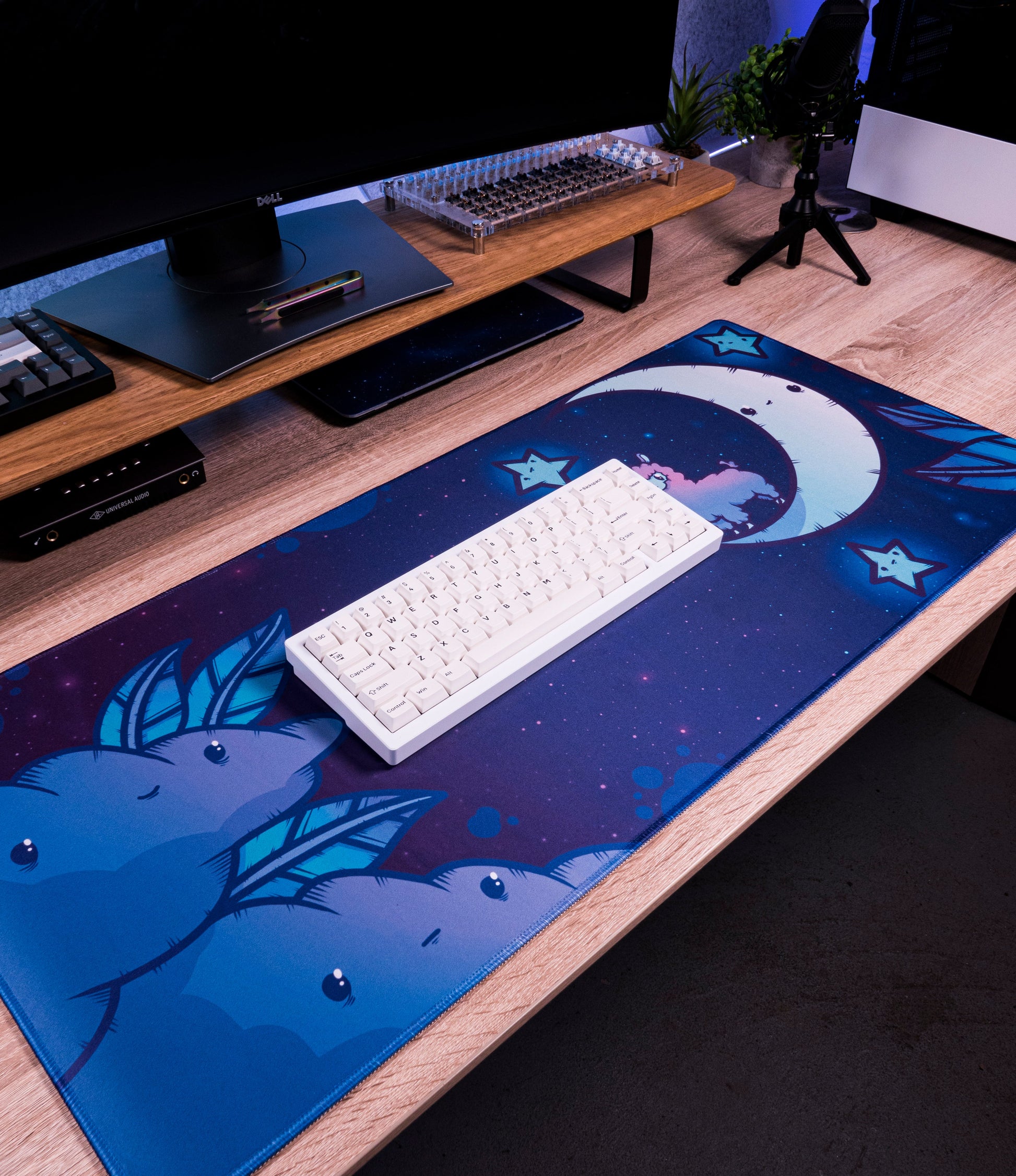 Blue desk mat with alpaca moon stars pattern; keyboard and devices placed on it