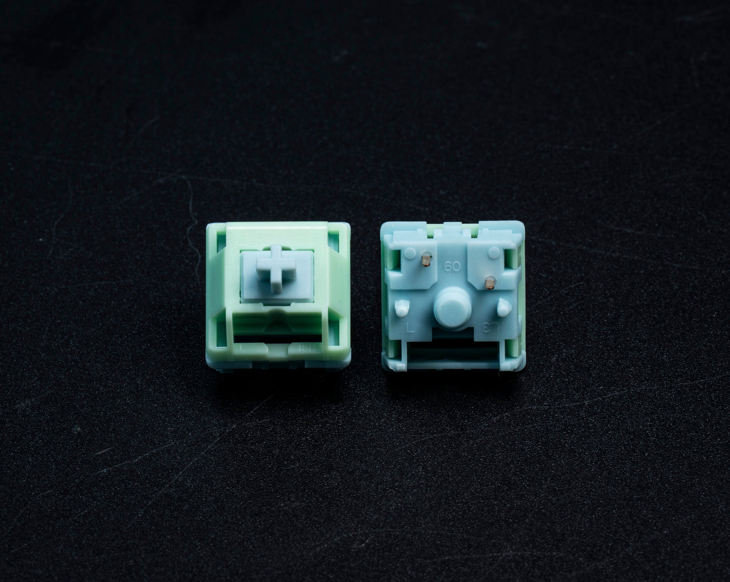 HMX Frog tactile switch pair with mint green/light blue housings and visible stems