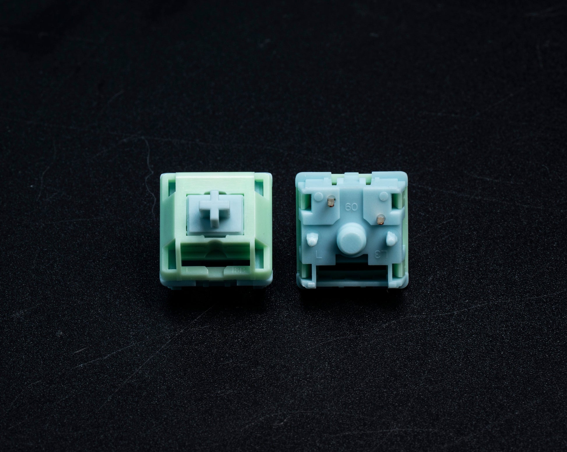 HMX Frog tactile switch pair with mint green/light blue housings and visible stems