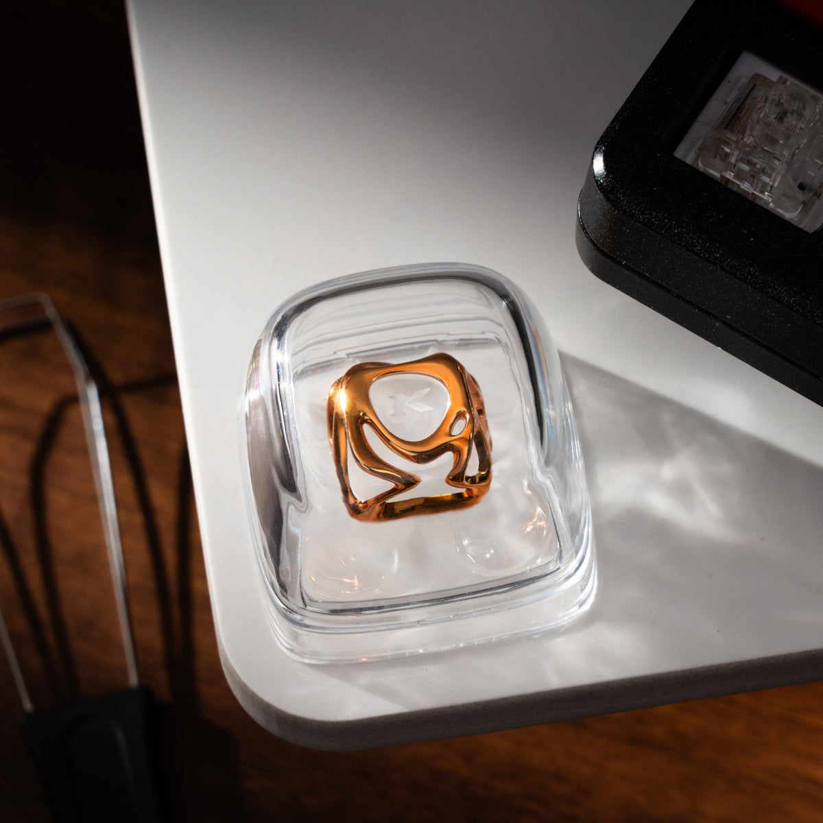 Golden electroplating keycap in clear case, star cutout visible on glossy top.