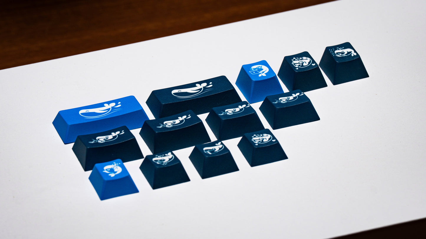 Blue keycaps arranged in grid, featuring whale and icon designs