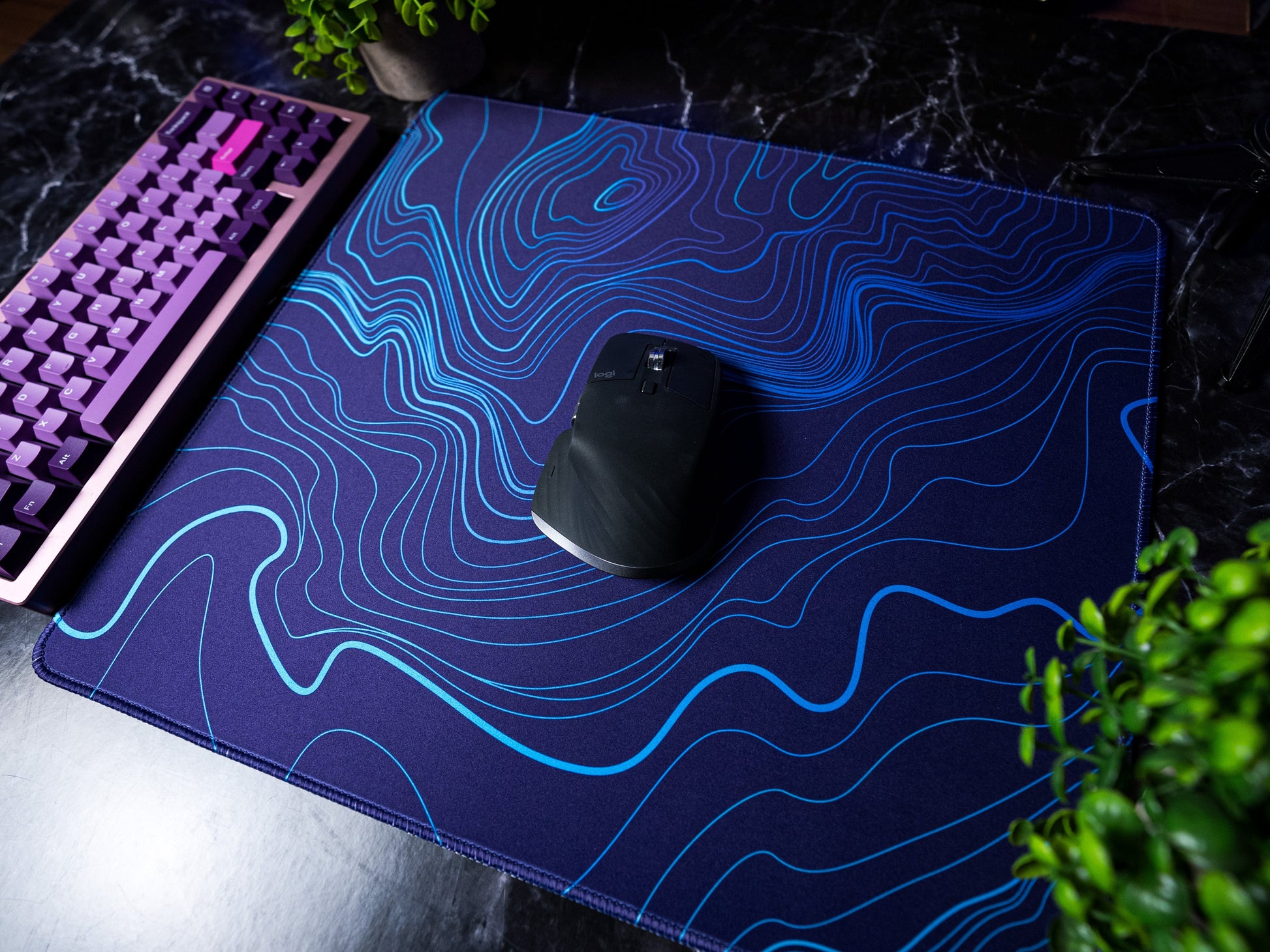 Purple-blue desk mat with blue topographic line pattern, mouse and keyboard corner
