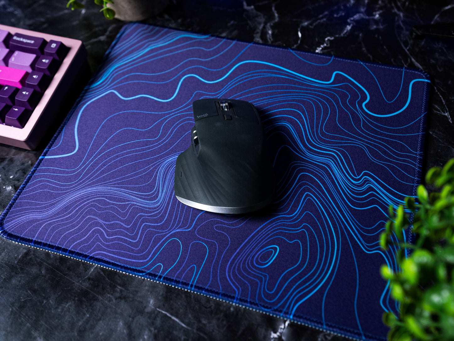 Purple-blue desk mat with blue topographic line pattern, mouse centered
