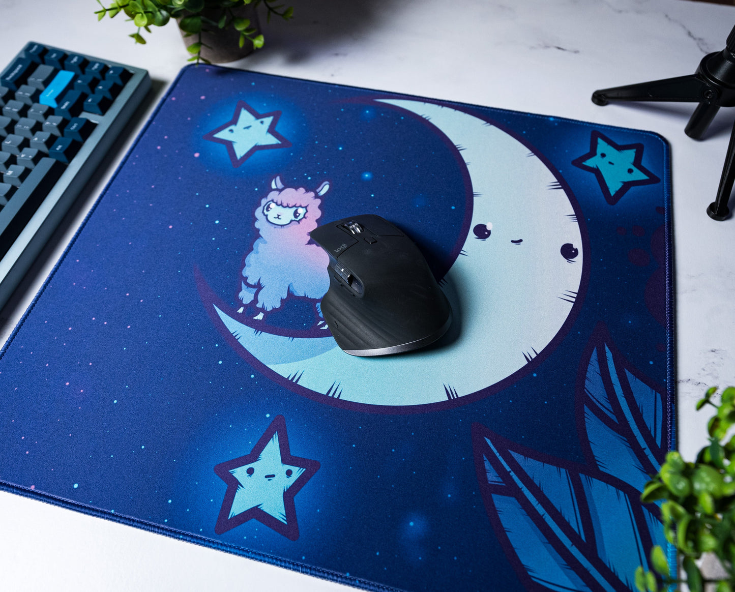 Blue desk mat with alpaca on crescent moon; black mouse centered