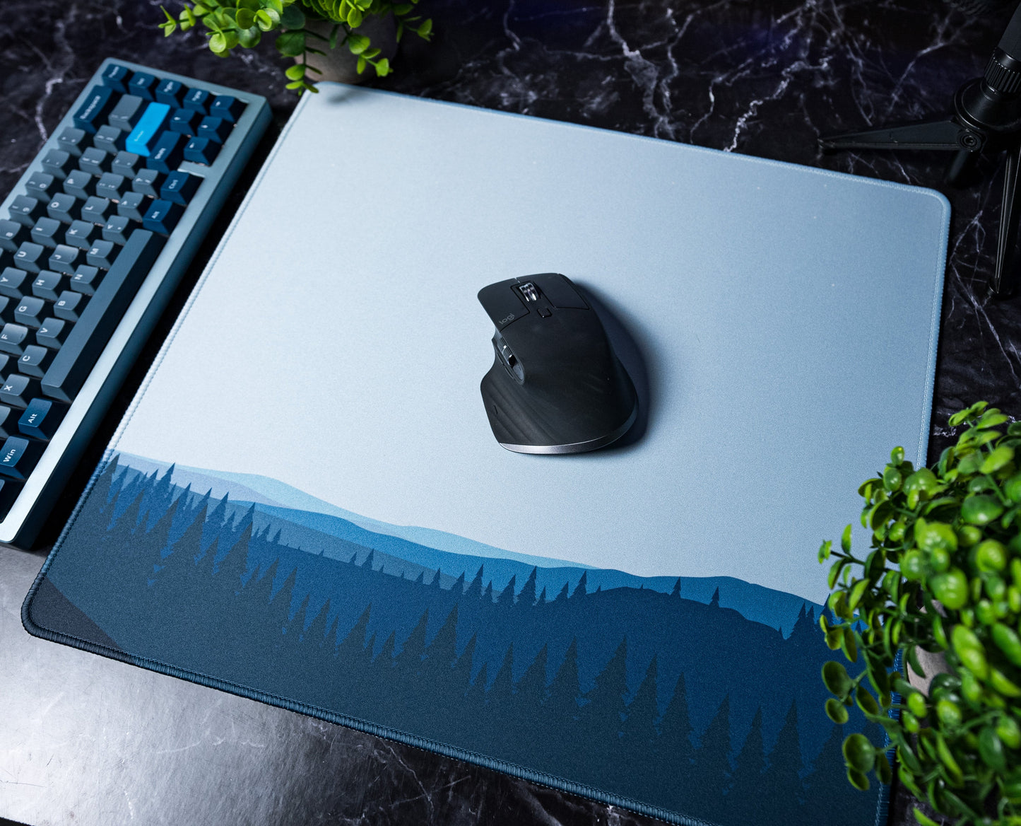 Large desk mat with blue forest horizon graphic, mouse centered on it