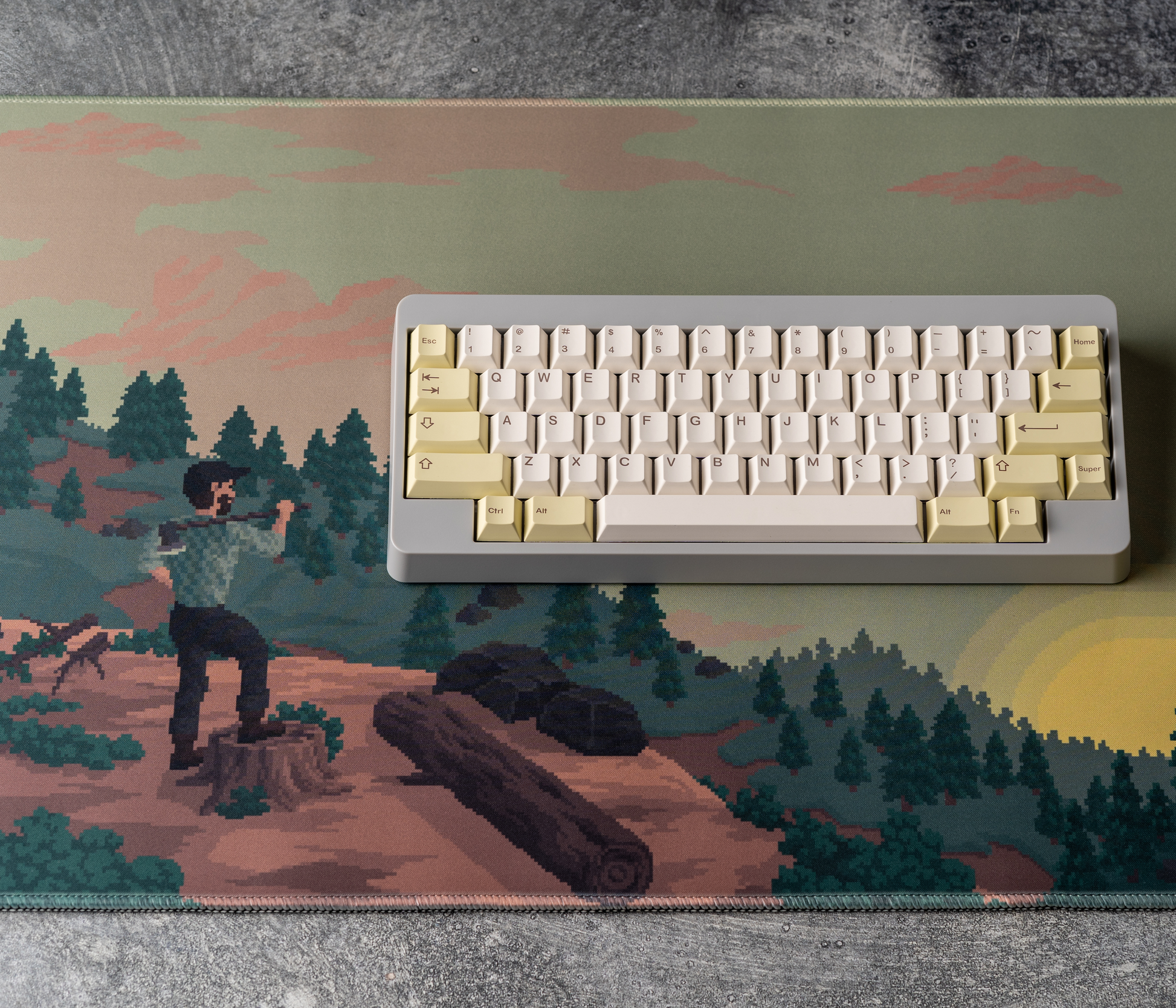 Rectangular desk mat with pixel art landscape print and stitched border; keyboard on top