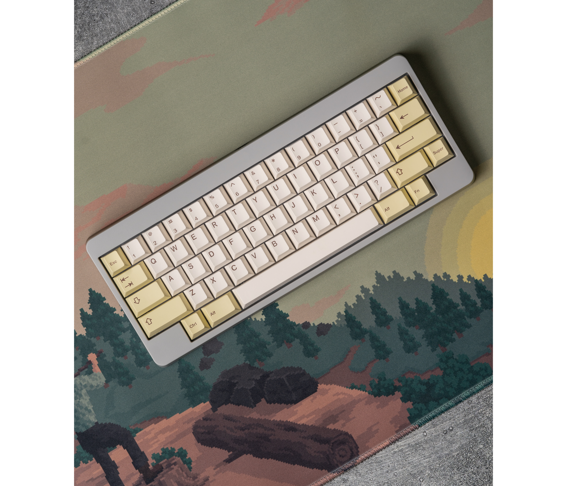 Rectangular desk mat with pixel art landscape print; compact keyboard centered on top