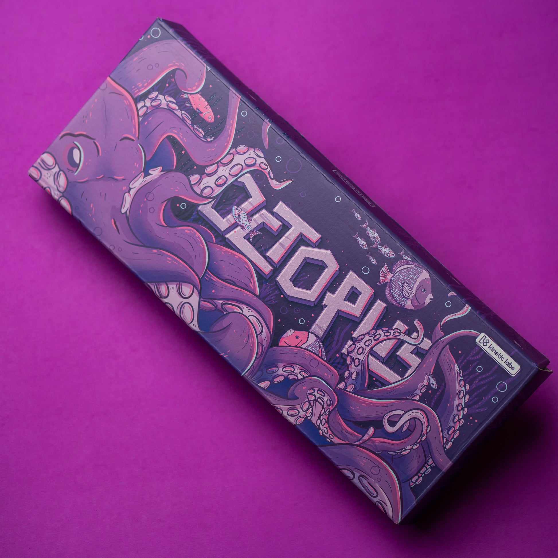 Printed purple keyboard box with octopus graphics and detailed undersea scene.