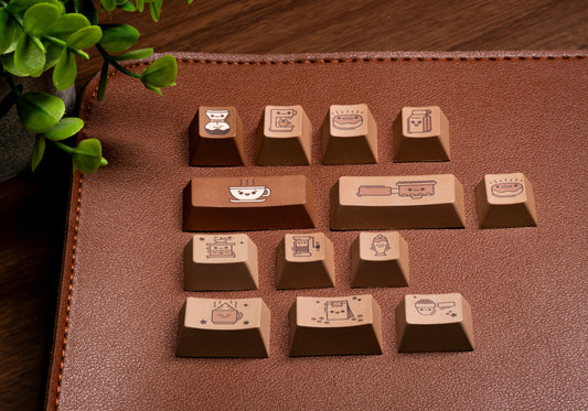 Coffee-themed PBT keycaps close-up on brown surface showing cup and bar icons