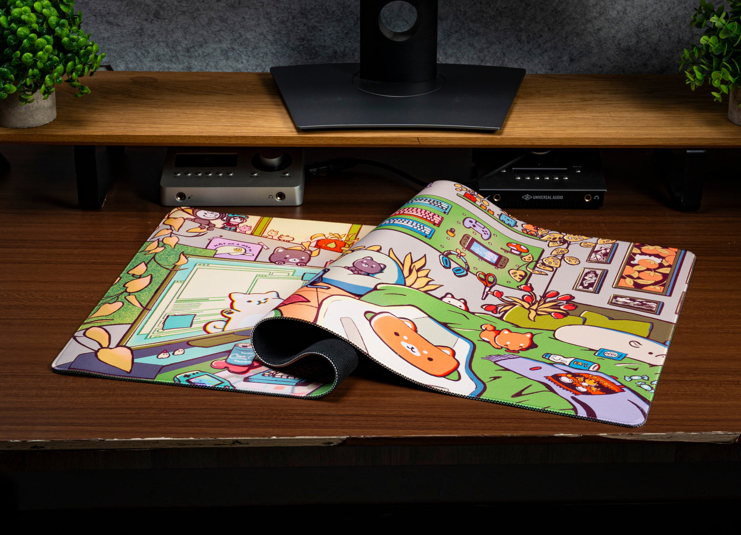 Cartoon desk mat with stitched edges, shown flat on a desk beside a mouse