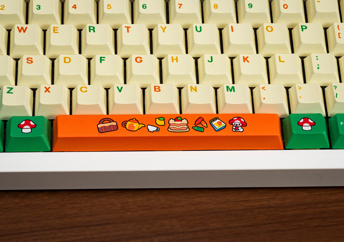 Keyboard keycap close-up: green keys with an orange spacebar showing cartoon icons