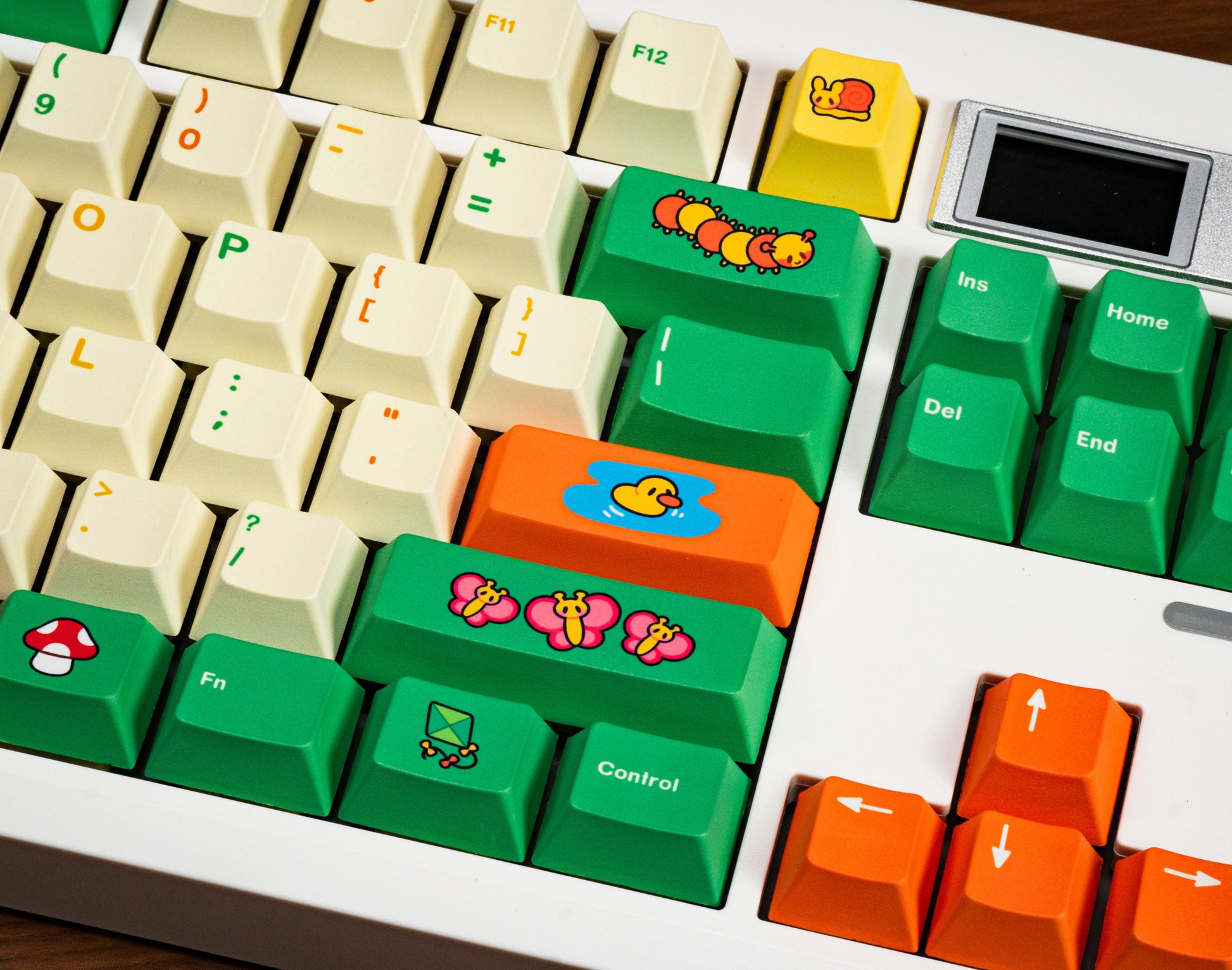 Close-up keycaps: green control keys and orange function keys with cartoon icons