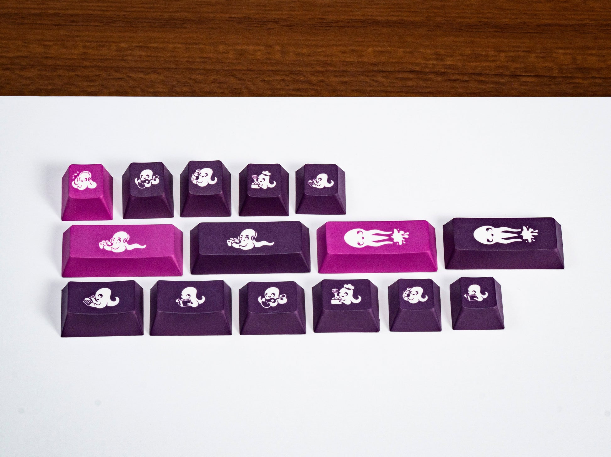 Small purple keycaps with octopus icons and a pink accent space bar.