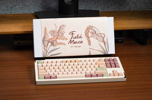 Pastel field mouse themed PBT keycaps in an open box, with mouse art and paw prints