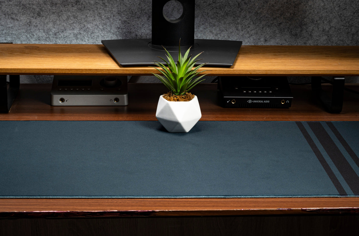 Dark blue desk mat with three vertical stripe accents and flat stitched border