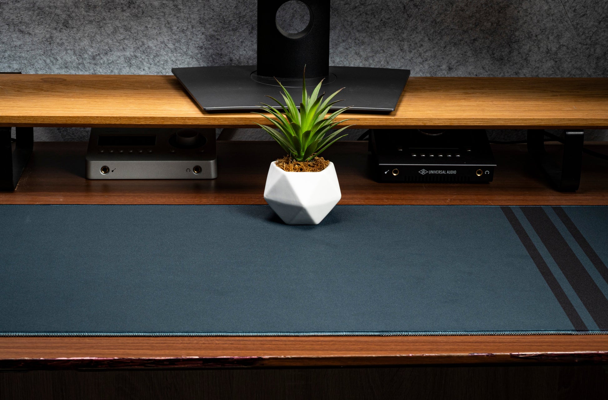 Dark blue desk mat with three vertical stripe accents and flat stitched border