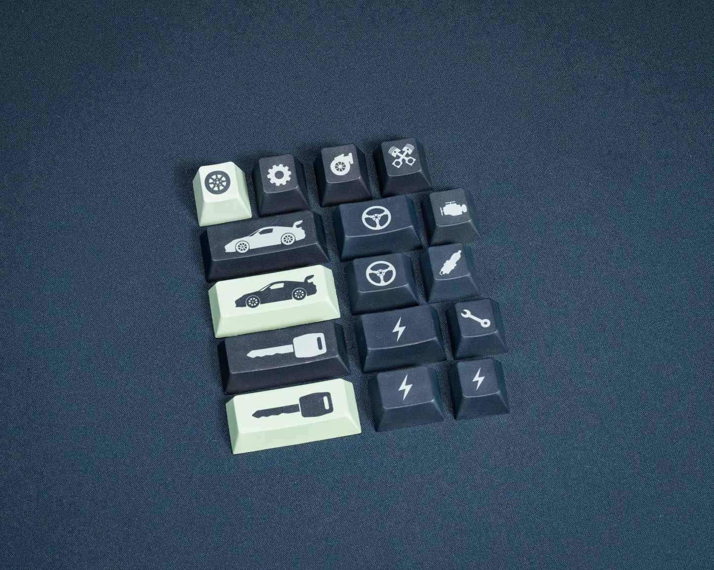 Assorted keycaps with car and tool icons, dark navy and pale mint keys