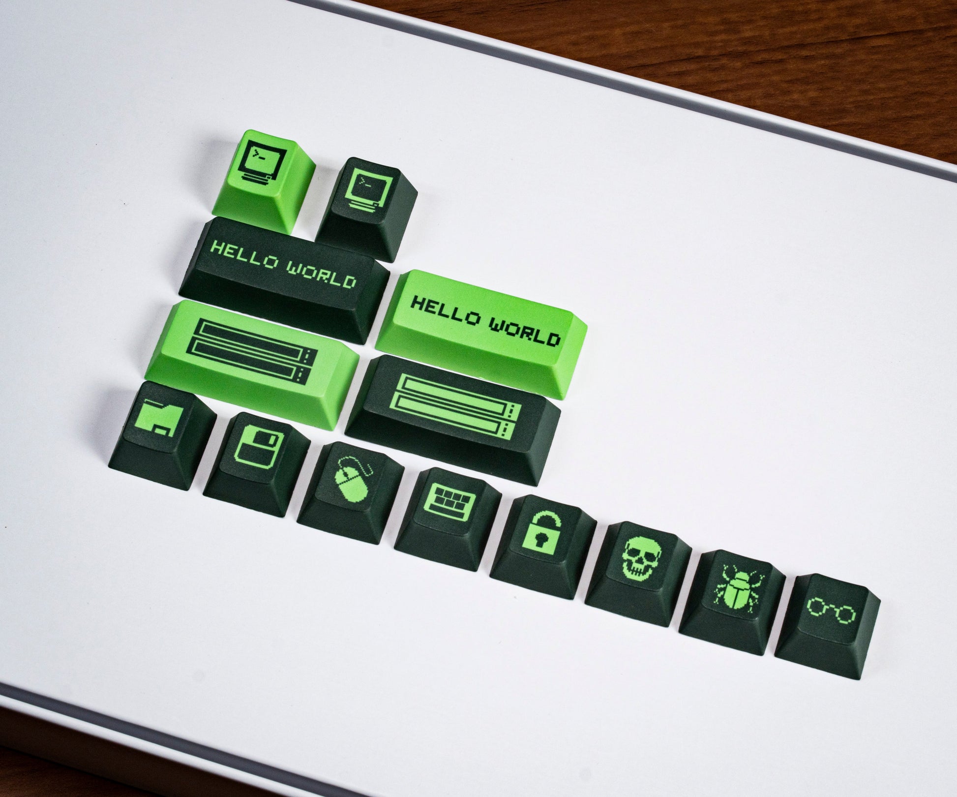 Cluster of green and black PBT keycaps with “Hello World” and game-like icons