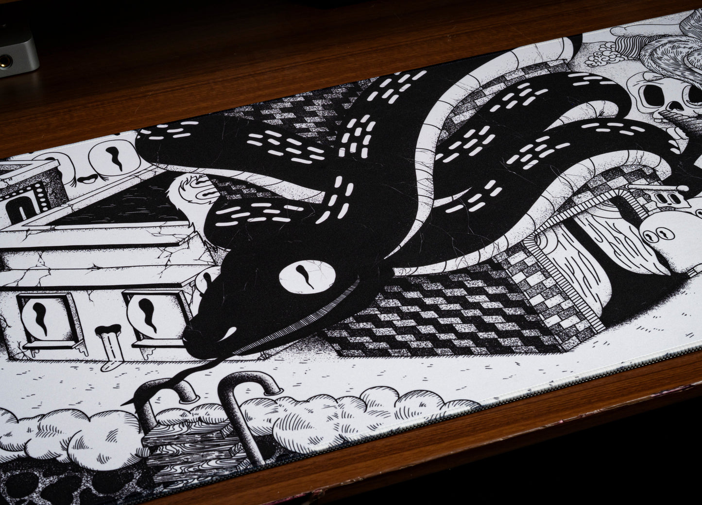 Black and white desk mat close-up with tentacle illustration and clouds