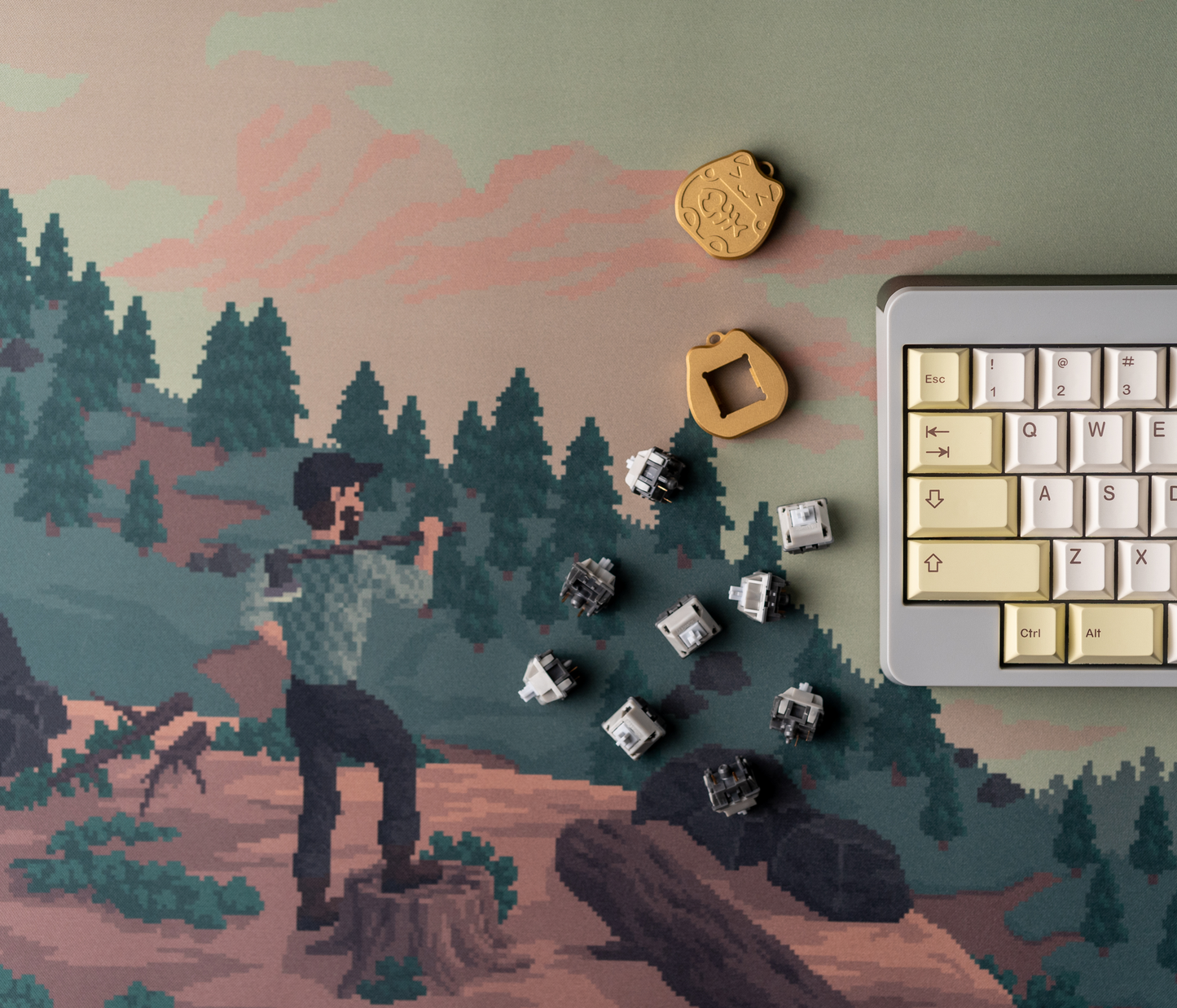 Rectangular desk mat with pixel art landscape print; coin pins and keyboard at corner