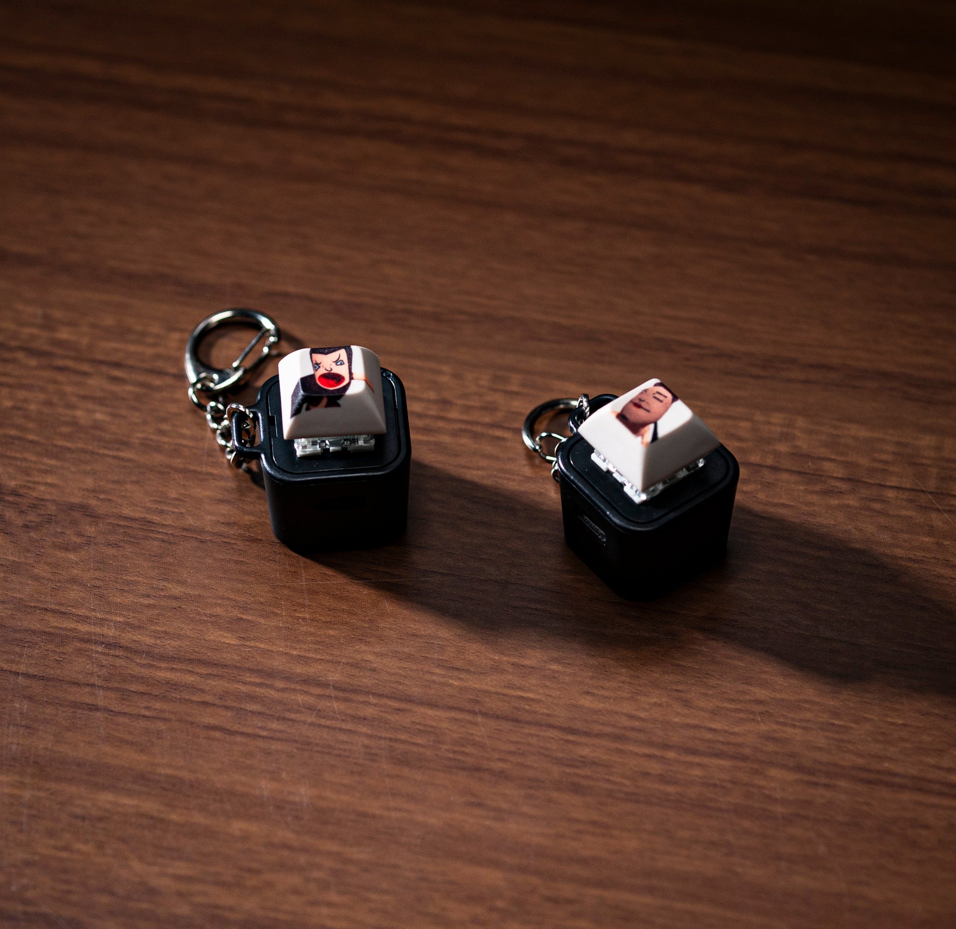 Pair of black keycap animation fidgets with character faces on white tops