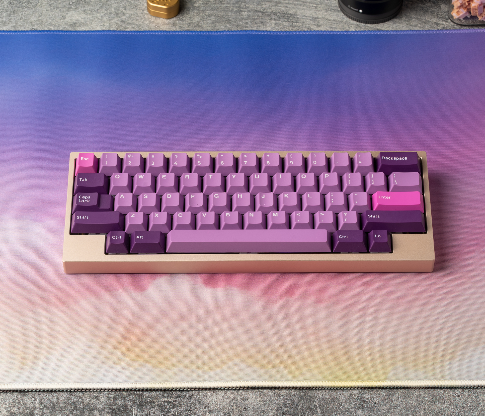 Desk mat with pastel clouds under a keyboard, showing purple and pink tones
