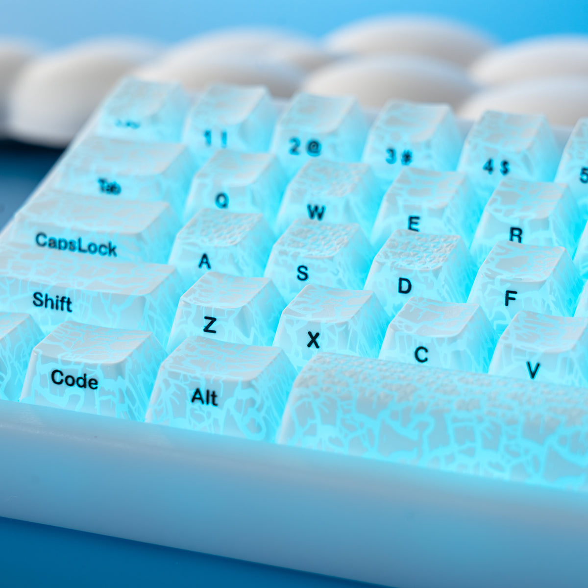 Blue-backlit ice-crack keycaps with Caps Lock, Shift, and Code legends