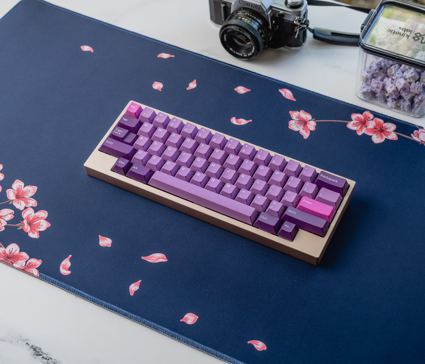 Navy desk mat with pink flowers and leaf specks; stitched edge