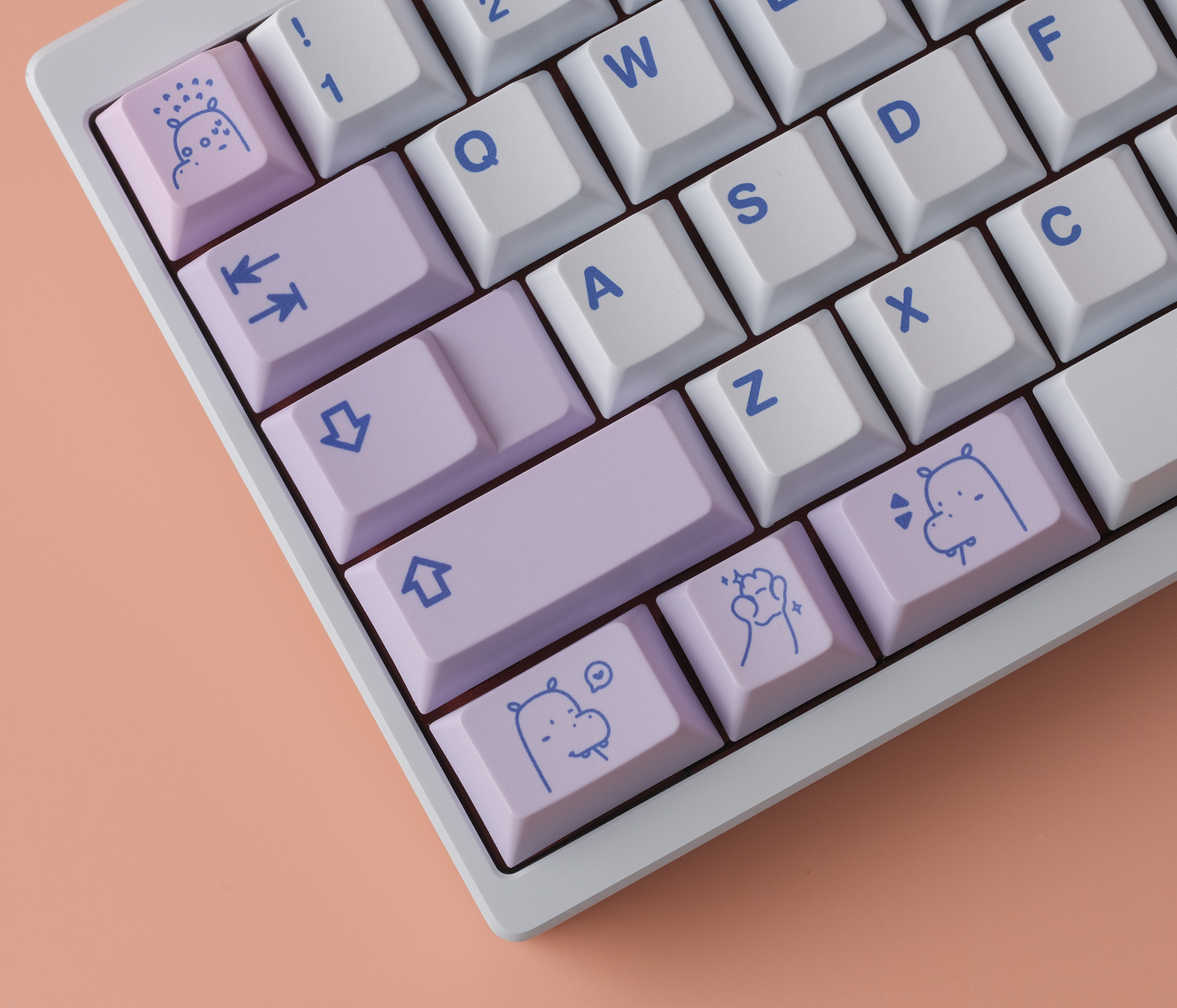 Purple and white keycaps close-up with animal icons and blue-letter legends