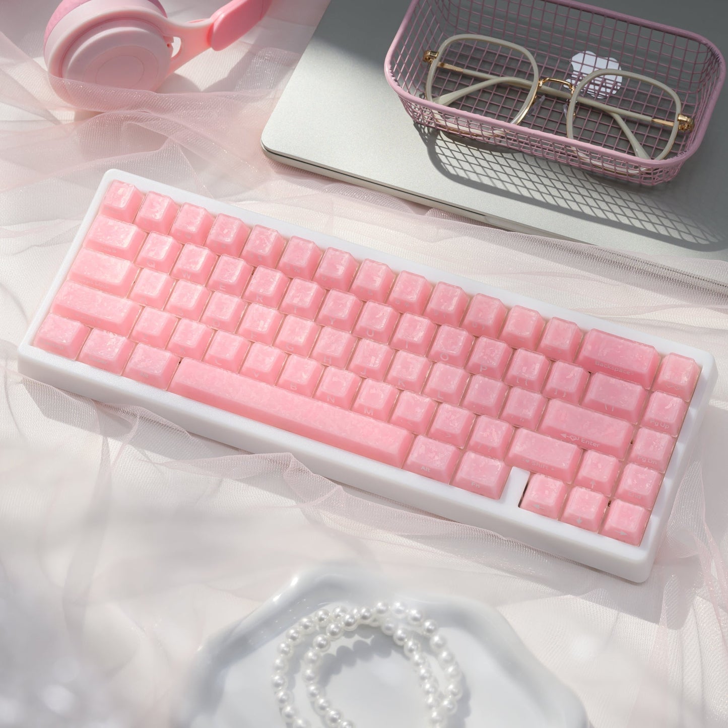Mechanical keyboard with pink translucent keycaps in a display tray