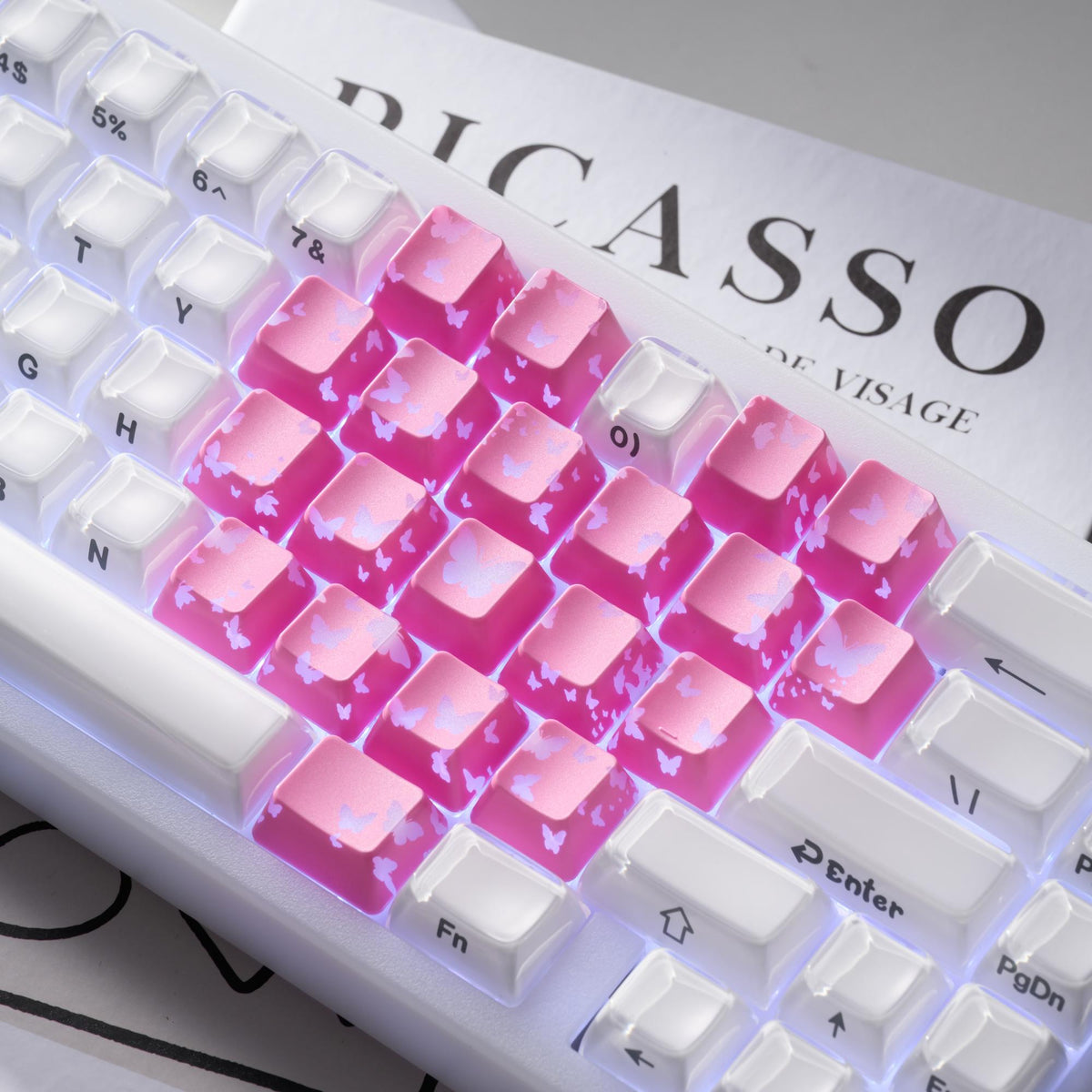 White keycaps with pink backlighting and butterfly cutout pattern across multiple keys