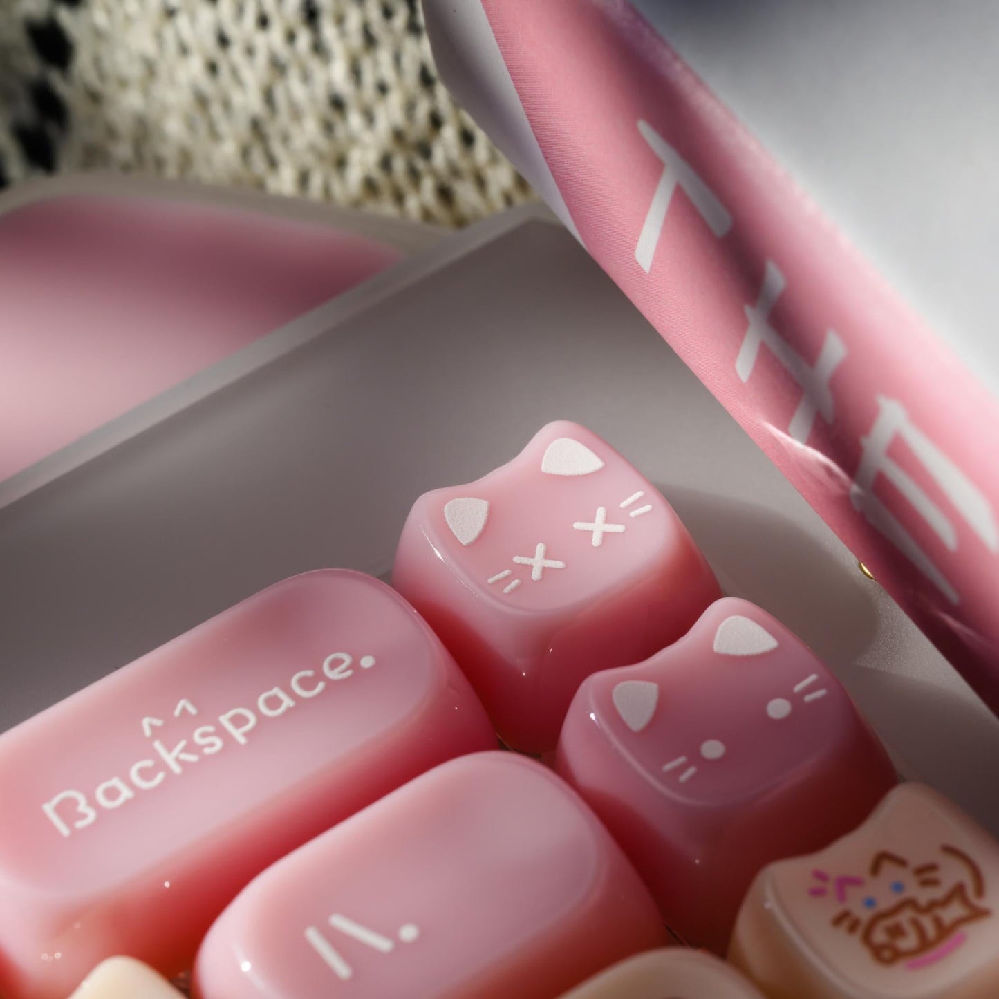Close-up of pink acrylic keyboard keycaps with paw icons and cat-themed symbols