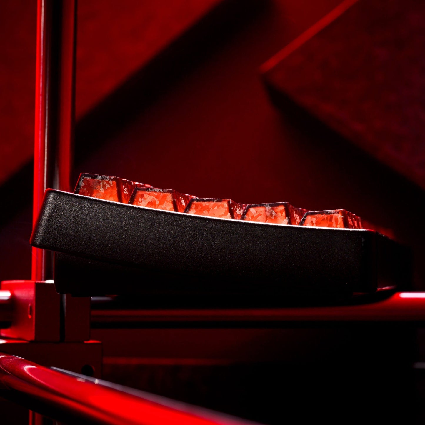 Mechanical keyboard side view with dark frame and backlit translucent keys, red glow