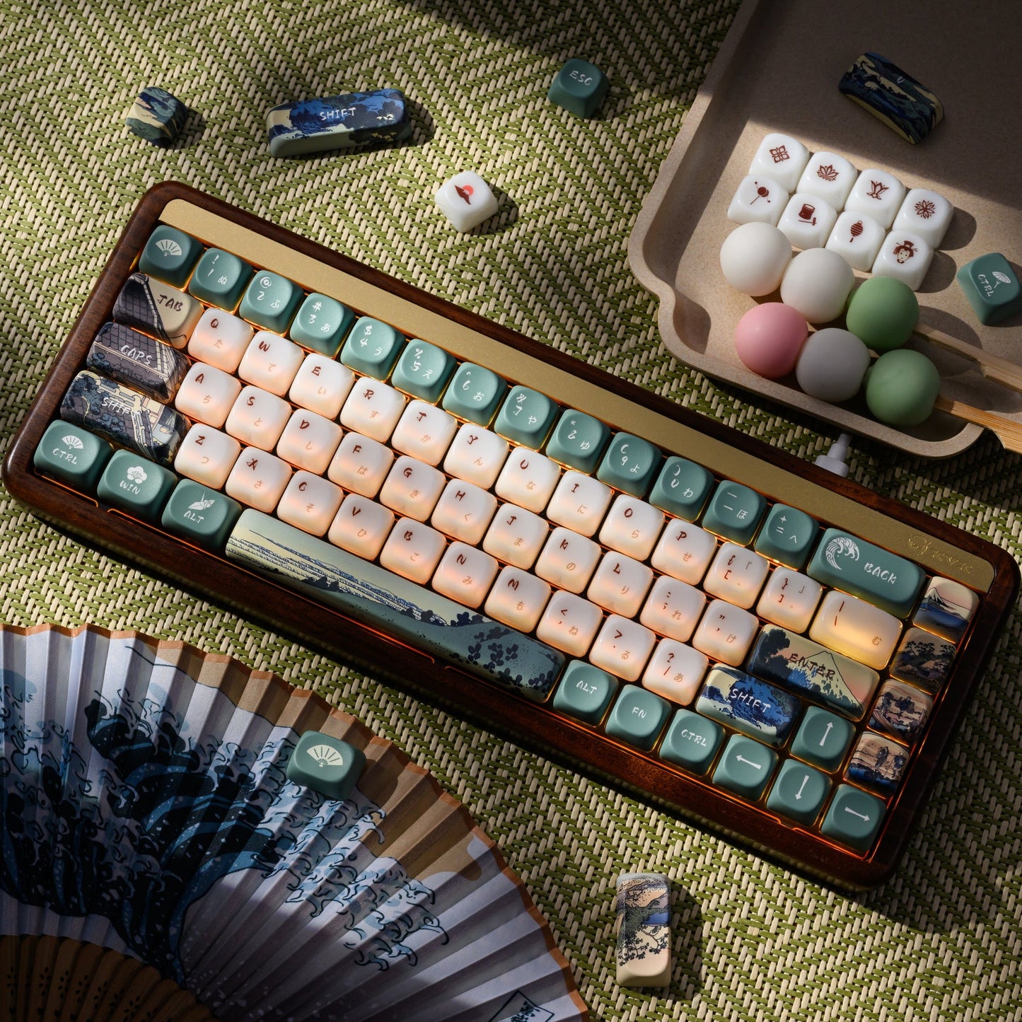 Long keycap set on green fabric with cream keys and blue printed landscape accents