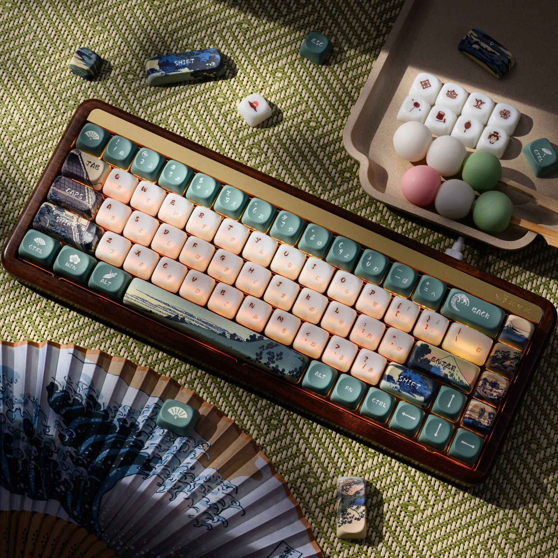 Long keycap set on green fabric with cream keys and blue printed landscape accents
