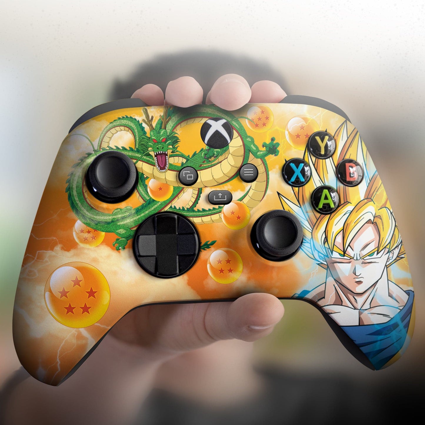 Xbox controller held in hand with Goku and Shenron themed front print and black controls